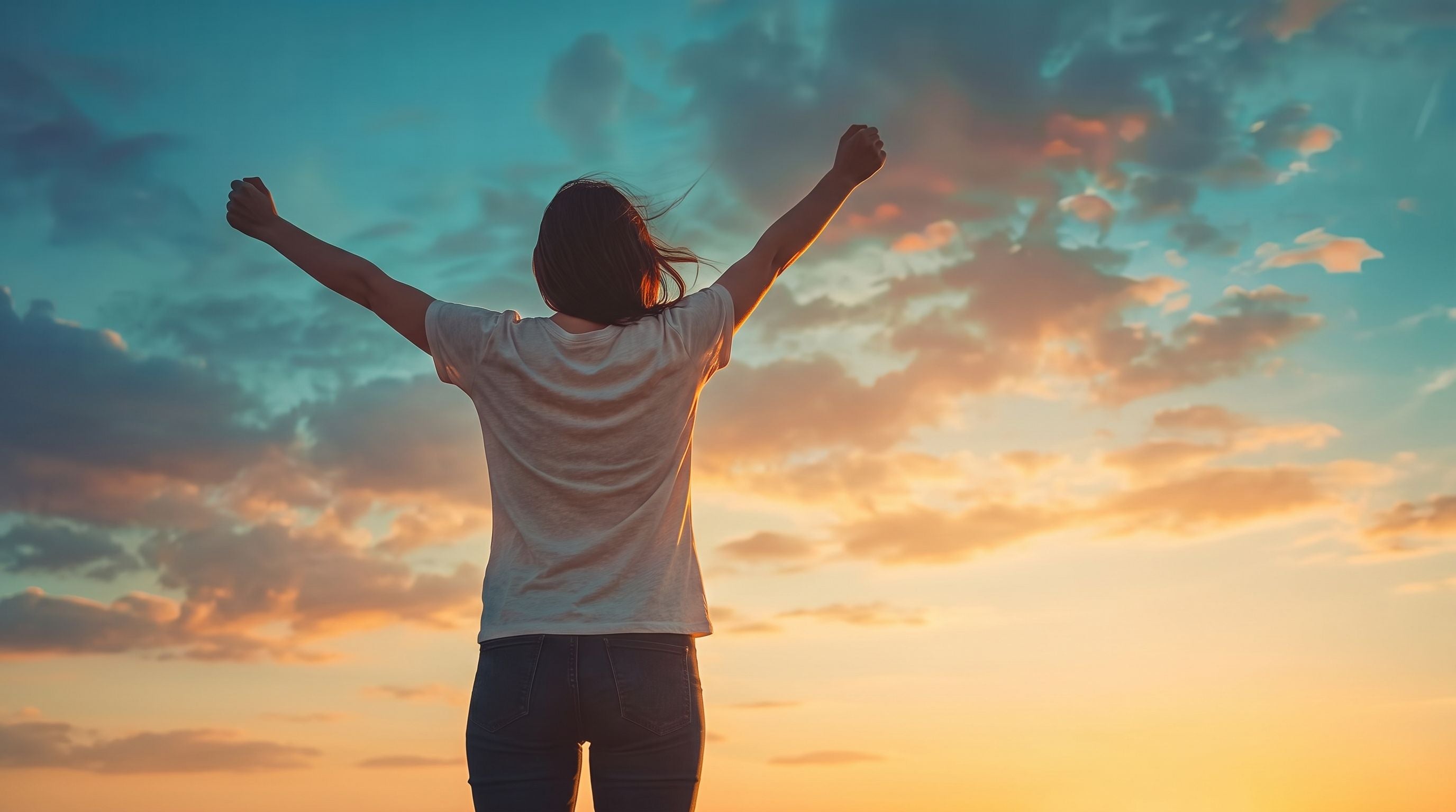 Translation missing: en.Woman in a t-shirt raising her arms toward a sunset — Frontier Apparel